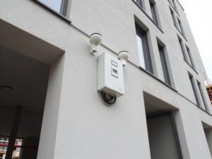 Neuer Alarmanlagen-Installationsbereich an einer deutschen Baustellenfassade mit Sensoren, Steuergerät und Verkabelung