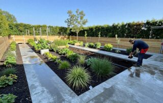 Weitwinkelaufnahme eines modernen deutschen Gartens in Bauphase mit einheimischen Pflanzen, Steinweg, Stützwand und Drainagesystem