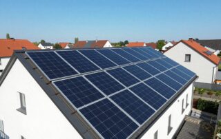 Moderne Solarpanels auf einem deutschen Wohnhausdach unter klarem Himmel, umgeben von Nachbarschaft und typisch deutscher Architektur
