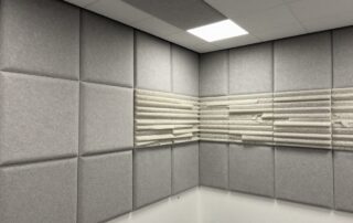 Moderne deutsche Büroeinrichtung mit akustischen Paneelen aus Mineralwolle an Wänden und Decke, sanft beleuchtet
