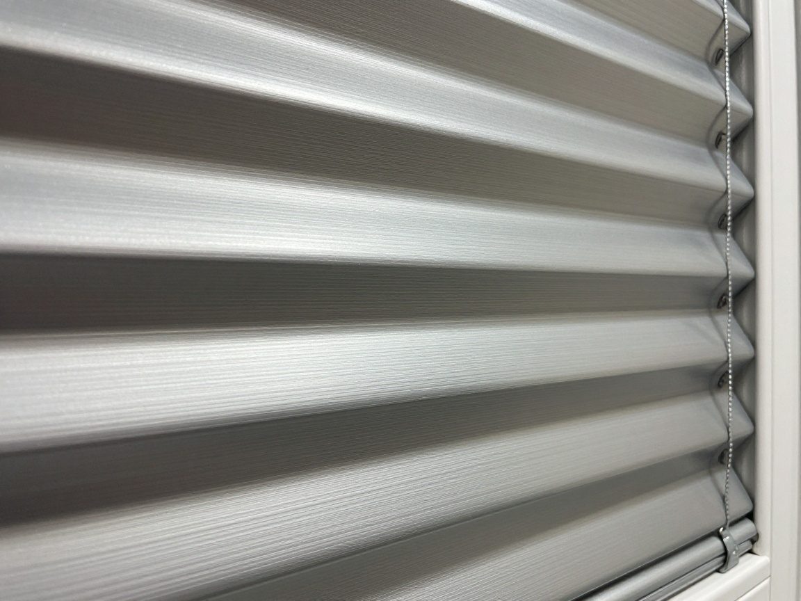 Nahaufnahme von Aluminiumjalousien mit feinen Rippen und mattem Finish, die 90 % UV‑Schutz bieten